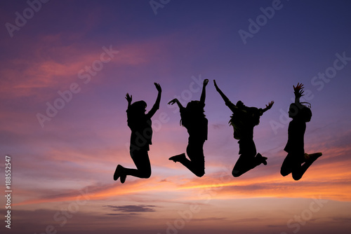 Silhouette of young people jumping together,friend having fun,happy friends with sunset background.Friendship Day,unity and freedom concept.