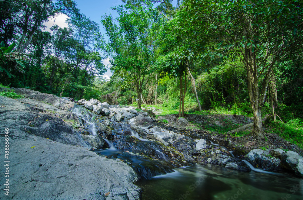 A small little waterfall falling on a small lake in Thailand A small little waterfall falling on a small lake in Thailand