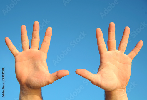 Male hand's on the sky background 