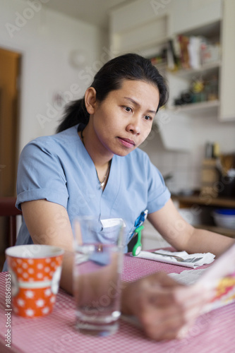 Female doctor sitting at table and reading papers photo