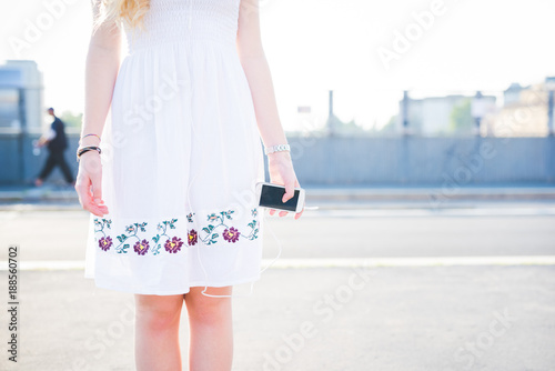 Midsection young woman holding smart phone outdoor - wifi technology, social network, communication concept