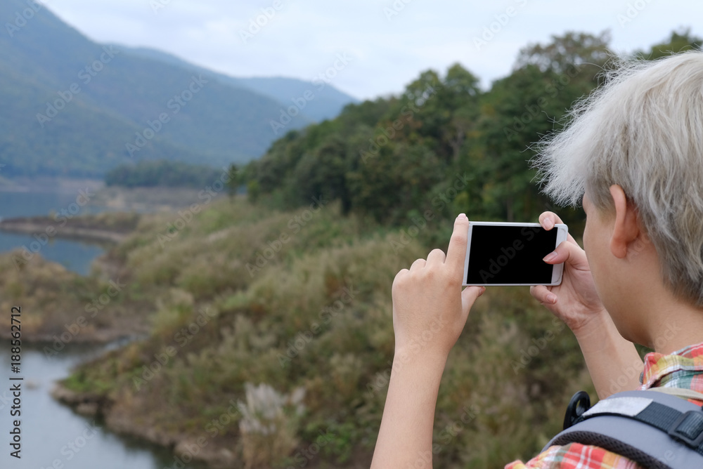 traveler man with backpack travel at forest & lake. tourist backpacker use smart phone to take photo. lifestyle, summer vacation concept traveler man with backpack travel at forest & lake. tourist backpacker use smart phone to take photo. lifestyle, summer vacation concept