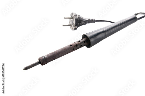 old, rusty soldering iron with a black handle and an old plug on a white background.
