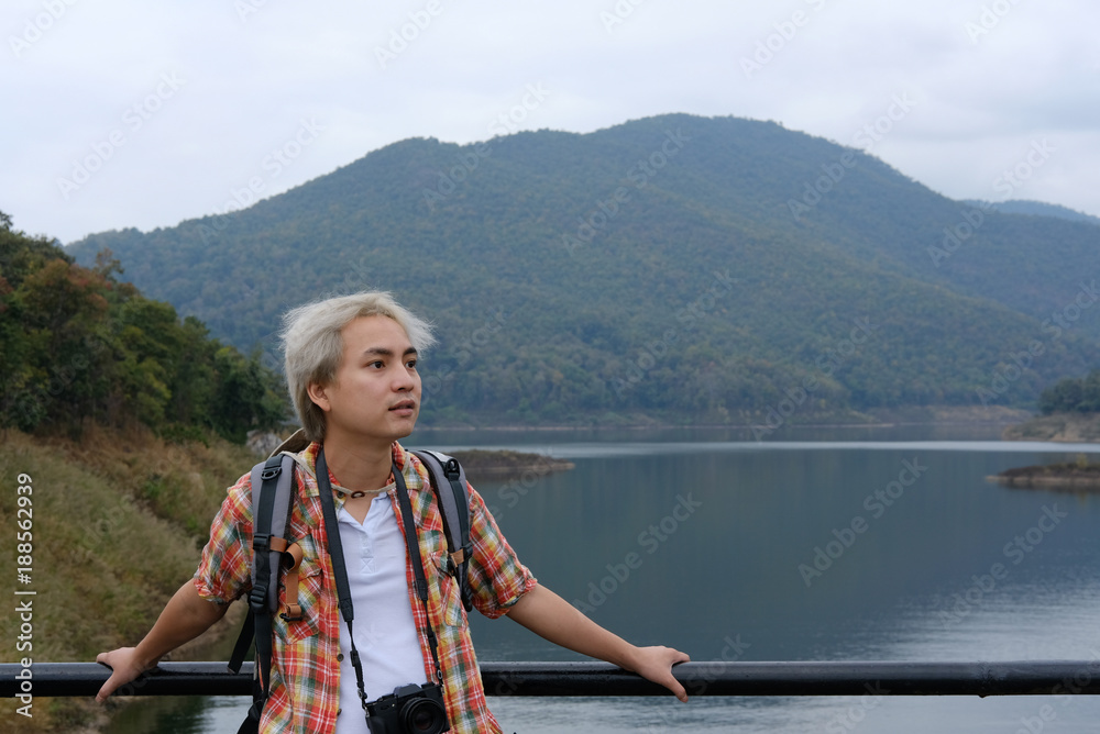 traveler man with camera & backpack travel at forest & lake. tourist backpacker relaxing outdoors. lifestyle, summer vacation concept traveler man with camera & backpack travel at forest & lake. tourist backpacker relaxing outdoors. lifestyle, summer vacation concept