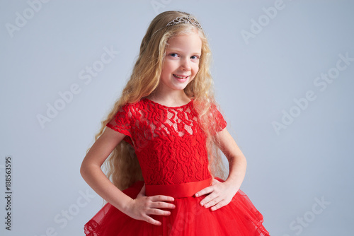 Smiling girl in red dress posing at camera
