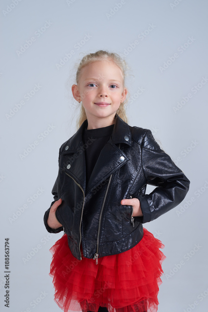 Small blonde girl in rock style outfit posing at camera Small blonde girl in rock style outfit posing at camera