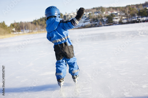 Rear view of boy ice skating