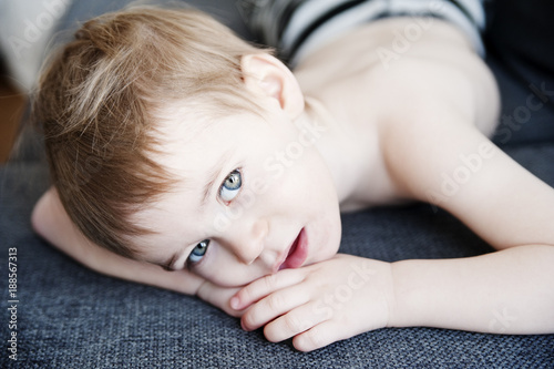 Shirtless boy lying on blanket