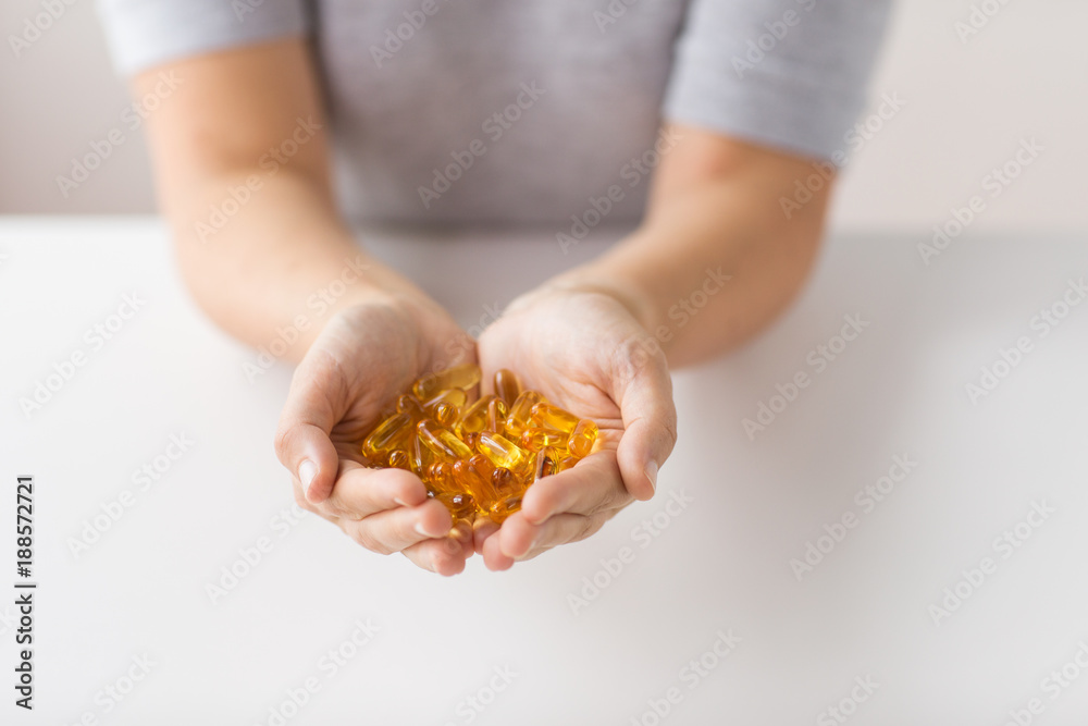 hands holding cod liver oil capsules hands holding cod liver oil capsules
