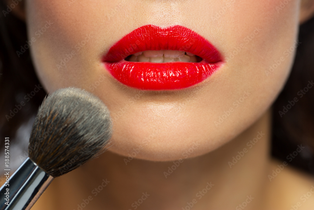 face of woman with red lipstick applying powder face of woman with red lipstick applying powder