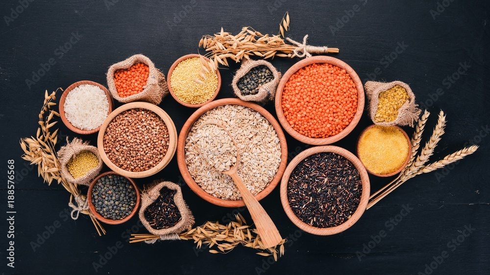 Set of Groats and Grains. Buckwheat, lentils, rice, millet, barley, corn, black rice. On a black background. Top view. Copy space. Set of Groats and Grains. Buckwheat, lentils, rice, millet, barley, corn, black rice. On a black background. Top view. Copy space.