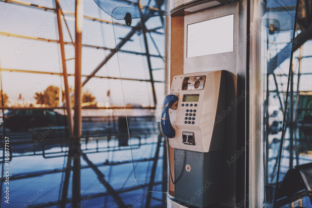 Side view of modern pushbutton payphone with white blank LCD screen