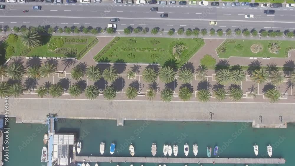 Overhead aerial view of boats in the port along city promenade with cars on the road Overhead aerial view of boats in the port along city promenade with cars on the road
