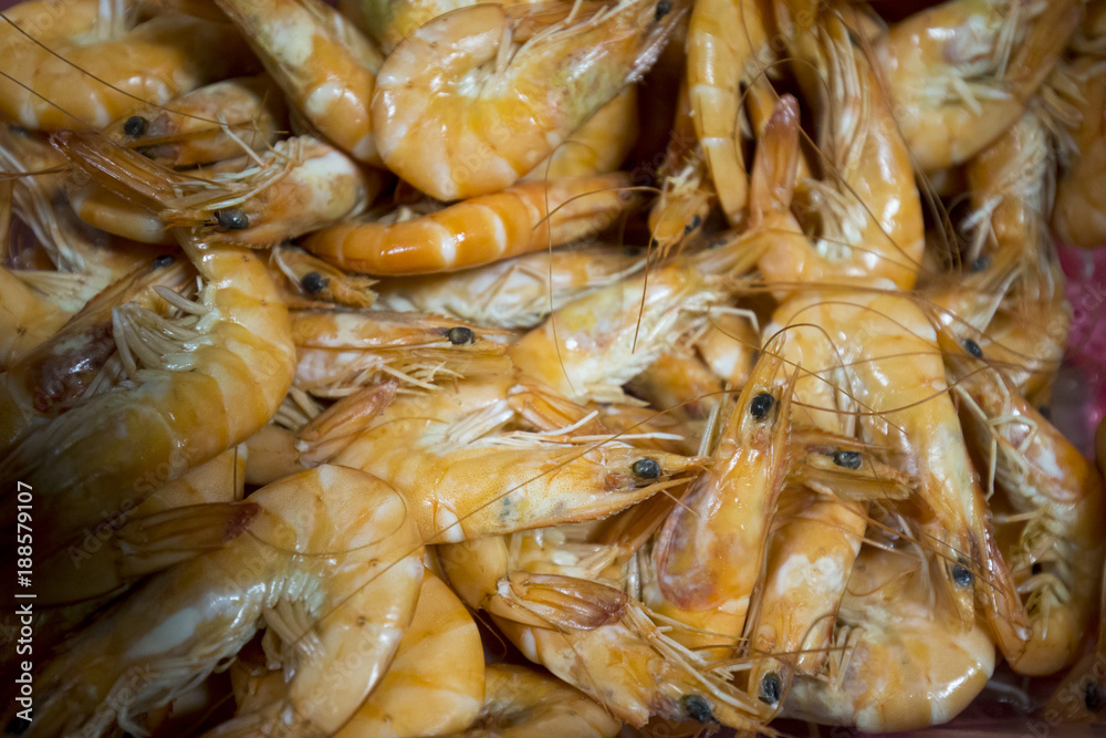 Cooked shrimp, detail on an orange background.