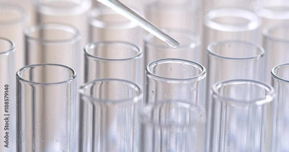 Pipette dropping sample into test tube Pipette dropping sample into test tube