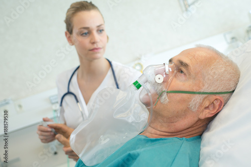 close-up of senior man using oxygen mask in clinic