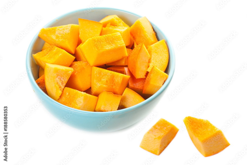  Pumpkin pieces in a  blue bowl isolated on white background. Diced Pumpkin, close up.Top view