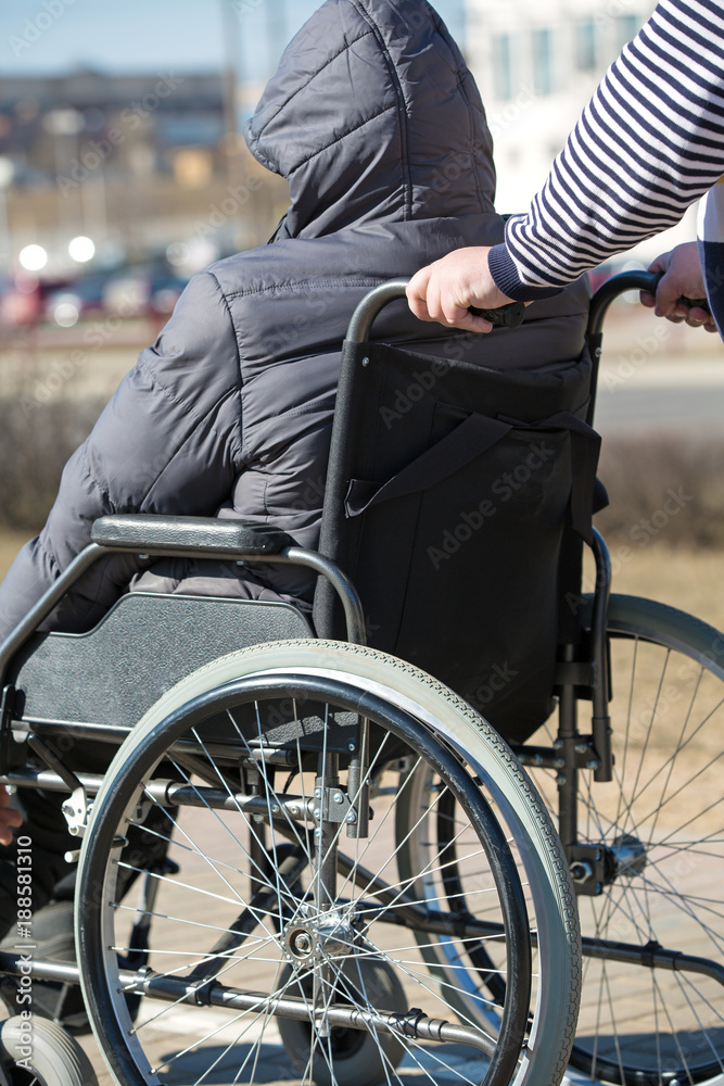 People with limited mobility take a walk with rollator wheelchair outdoors People with limited mobility take a walk with rollator wheelchair outdoors