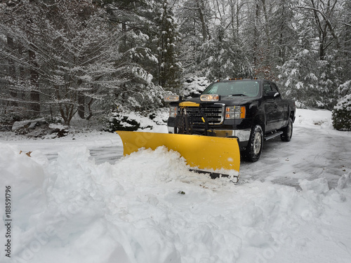 snow plow clearing a parking lot after  storm