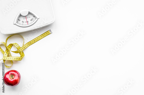 Lose weight concept. Scale and measuring tape on white background top view copy space