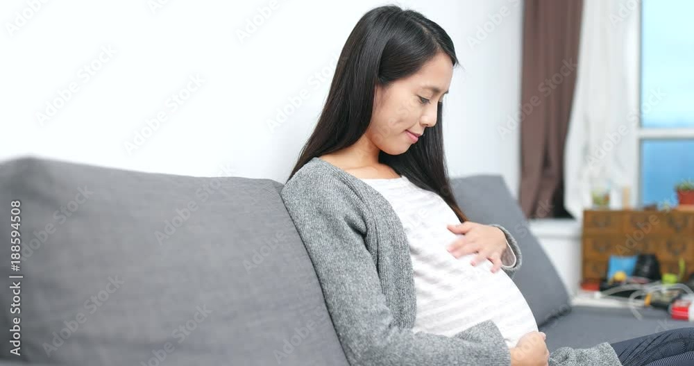 Young Pregnant woman looking of her tummy at home Young Pregnant woman looking of her tummy at home