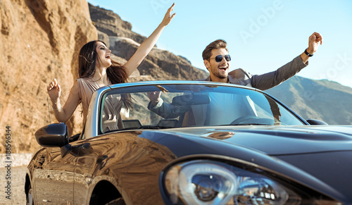 Smart couple riding a luxurious convertible