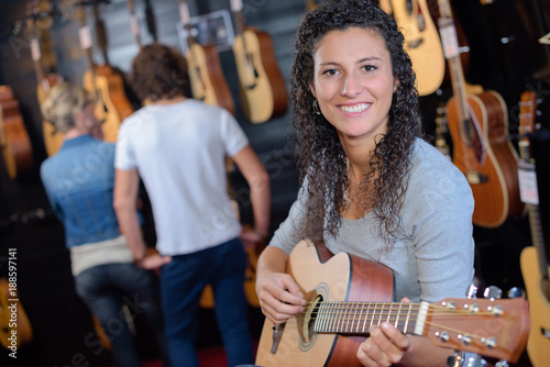 woman holding a guitar in the guitar store