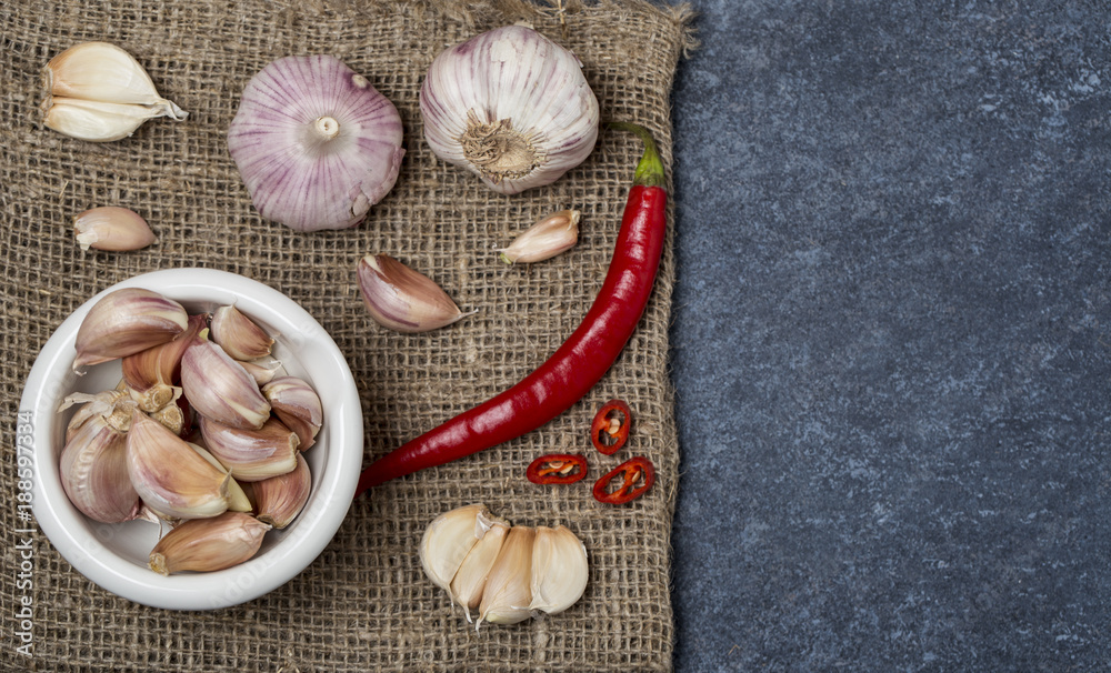 Fresh garlic with chili pepper on dark background. Garlic bulbs