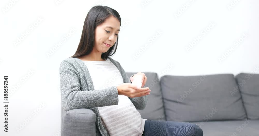 Pregnant woman eating supplement at home Pregnant woman eating supplement at home