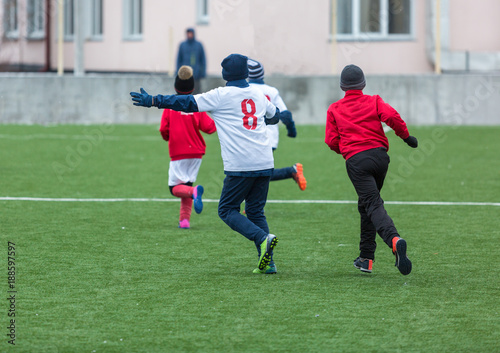 kids play footballon stadium at winter