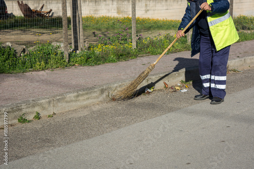 Horizontal View of a Dustman Working in the Street Using a Wooden Mop and Dressing a Yellow Jacket