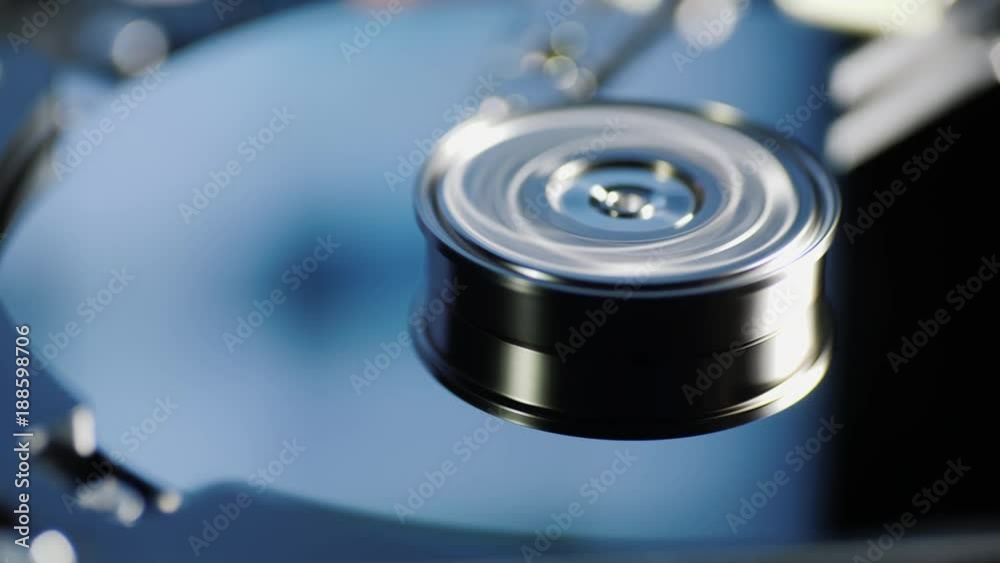 Computer running hard drive. Information from the monitor is reflected in the plates of the disk. Day center concept Computer running hard drive. Information from the monitor is reflected in the plates of the disk. Day center concept