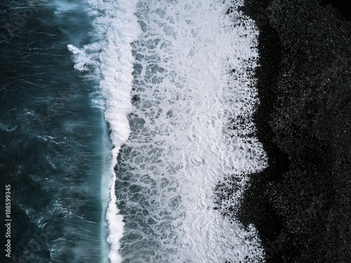 Aerial view of waves on black sand beach photo