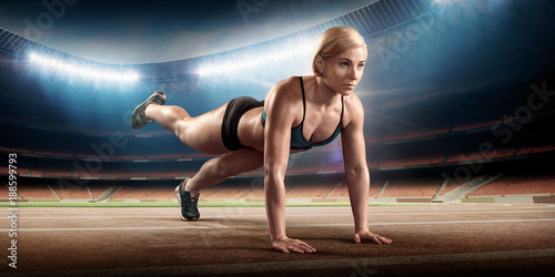 Female athlete on stadium doing push ups