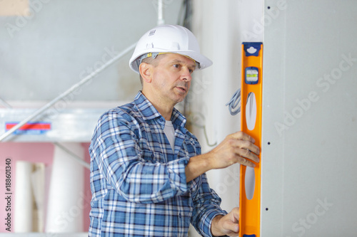 professional builder with spirit level at construction site