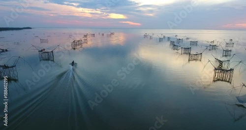 4k aerial movie of Thai fisherman Catching Fish with Large fishing net in the Morning at Ban Pak Pra -Talay Noi Lake, Phatthalung, Thailand photo