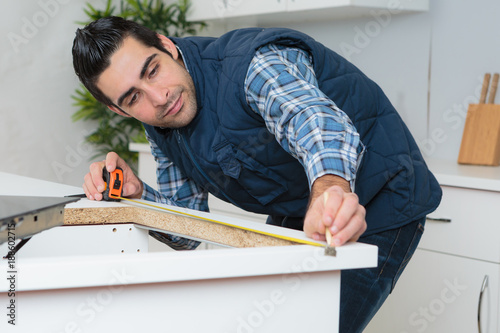 Photography man measuring worktop to fit new hob