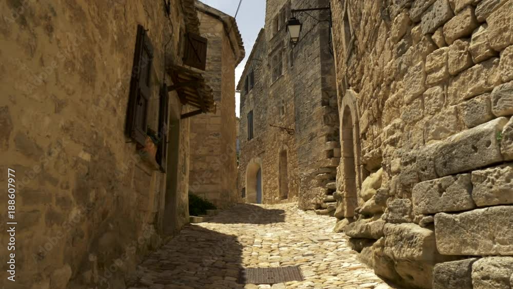 Walking along the paved street of a medieval town Lacoste, France. 4K, UHD