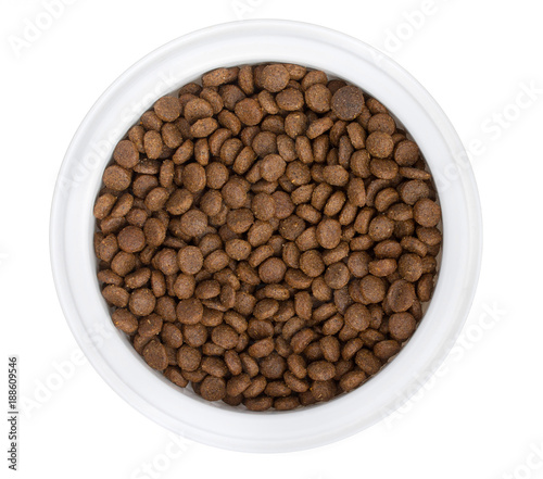 White plastic bowl with dry dog food, isolated on white background. Top view, close up.