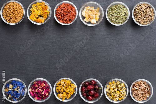 Fotografie Selection of dried herbs on a dark background with copy space, top view