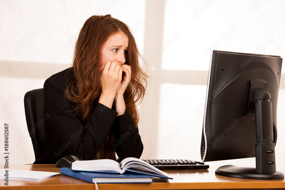 Frightened stressed woman working at her desk in the office, reading bad report. Frightened stressed woman working at her desk in the office, reading bad report.