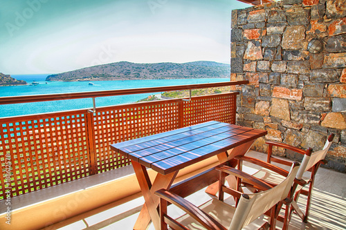 Table and chairs on a balcony with sea view  Greece