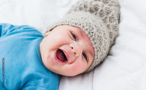 close up of smiling baby lying in his crib