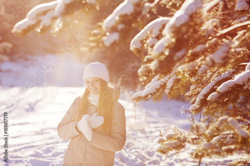 Beautiful girl in the winter park. Sunny day. Backlit.