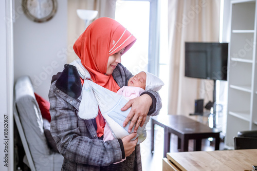 Photography A mother from Indonesia with her newborn baby pose in and around their apartment