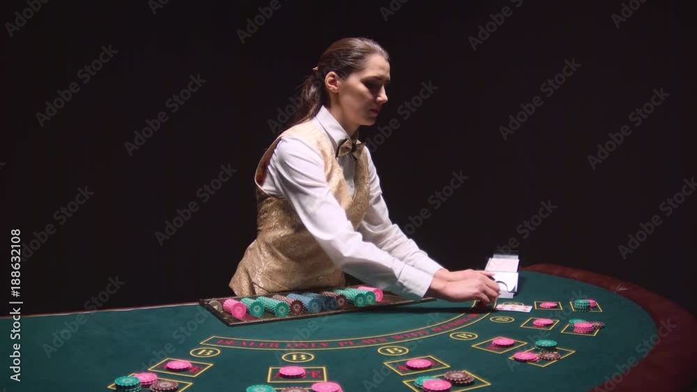 Poker game dealer hands out cards on a green table. Black background. Slow motion Poker game dealer hands out cards on a green table. Black background. Slow motion