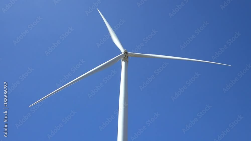 Wind turbine on the green grass over the blue clouded sky. Wind turbine on the green grass over the blue clouded sky.