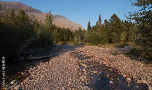 WILBUR CREEK ON THE SWIFTCURRENT HIKING TRAIL NEAR FISHERCAP LAKE IN THE MANY GLACIERS REGION OF GLACIER NATIONAL PARK DURING THE 2017 FALL FIRES IN MONTANA UNITED STATES photo