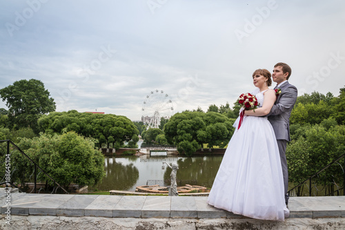 Bride and groom walking in summer park