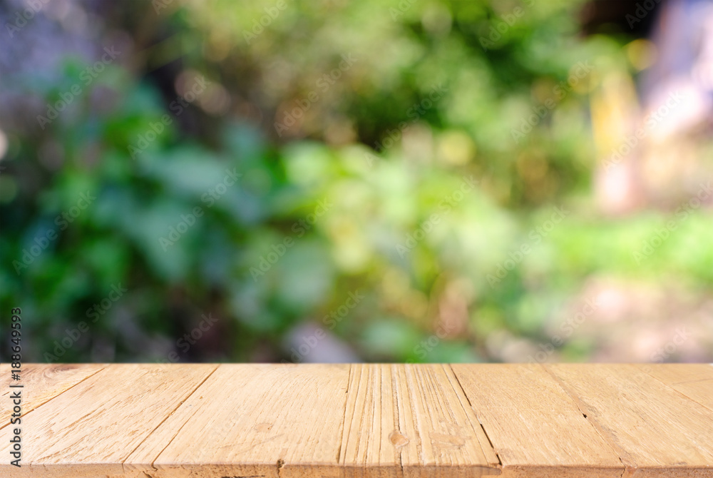 image of wooden table in front of abstract blurred background of outdoor garden lights. can be used for display or montage your products.Mock up for display of product